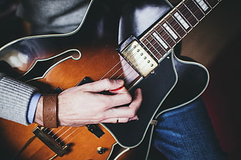 Close-up of musician playing hollow-body electric guitar