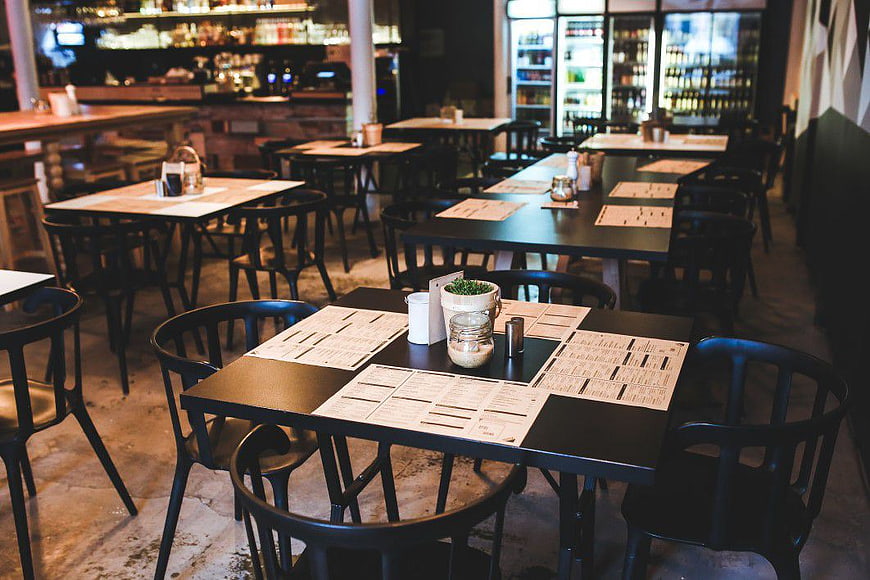 Empty rustic restaurant interior with tables and menus