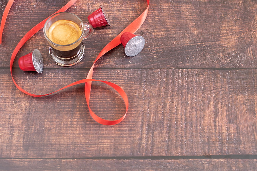Flat lay of espresso coffee with red ribbon on rustic wood