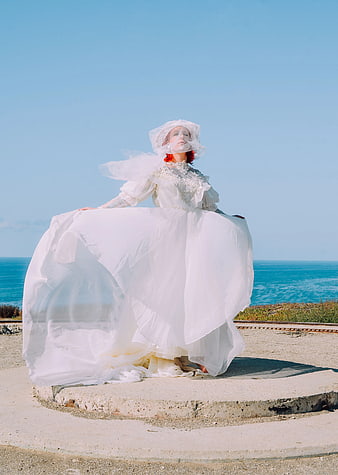 Woman in Vintage White Wedding Dress by the Sea