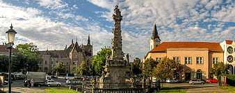 Panoramic view of historic European town square with plague column