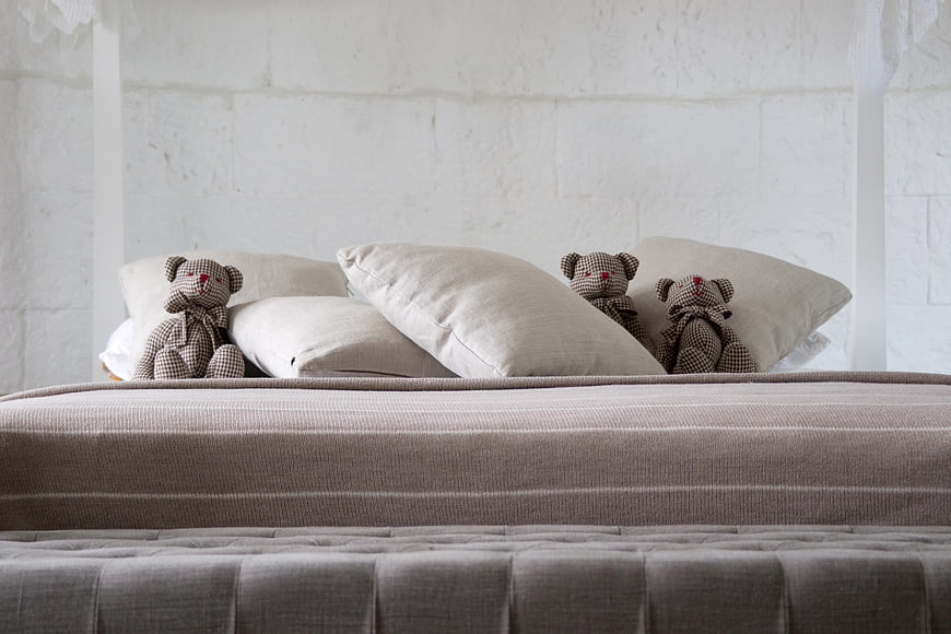 Cozy Bedroom Bed With Teddy Bears And White Brick Wall