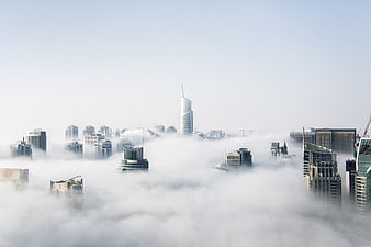 Modern skyscrapers emerging from thick fog in a city skyline