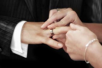 Close-up of wedding ring exchange on groom's finger