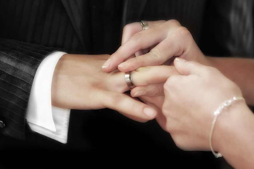 Close-up of wedding ring exchange on groom's finger