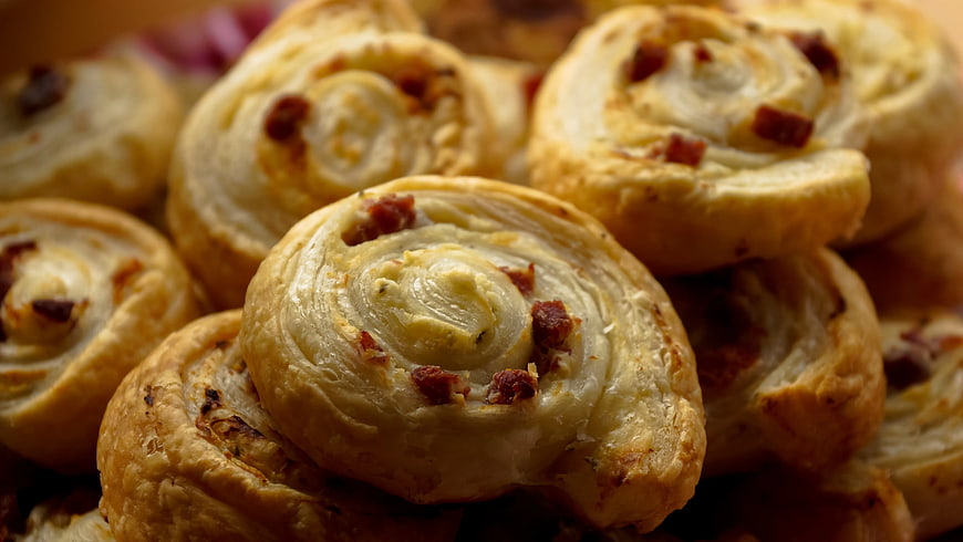 Close-up of golden baked pastry rolls with savory filling