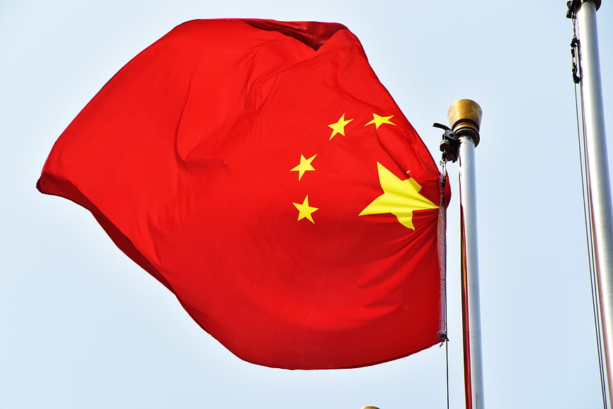 Chinese National Flag Waving Against Clear Blue Sky