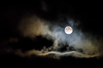 Full Moon Illuminating Dark Clouds at Night
