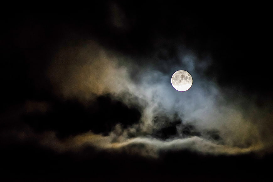 Full Moon Illuminating Dark Clouds at Night
