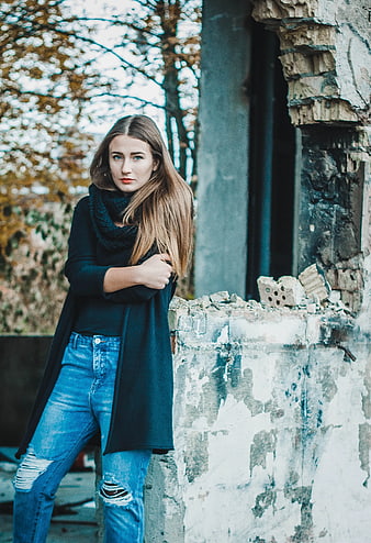 Young Woman in Black Cardigan and Jeans by Ruined Wall