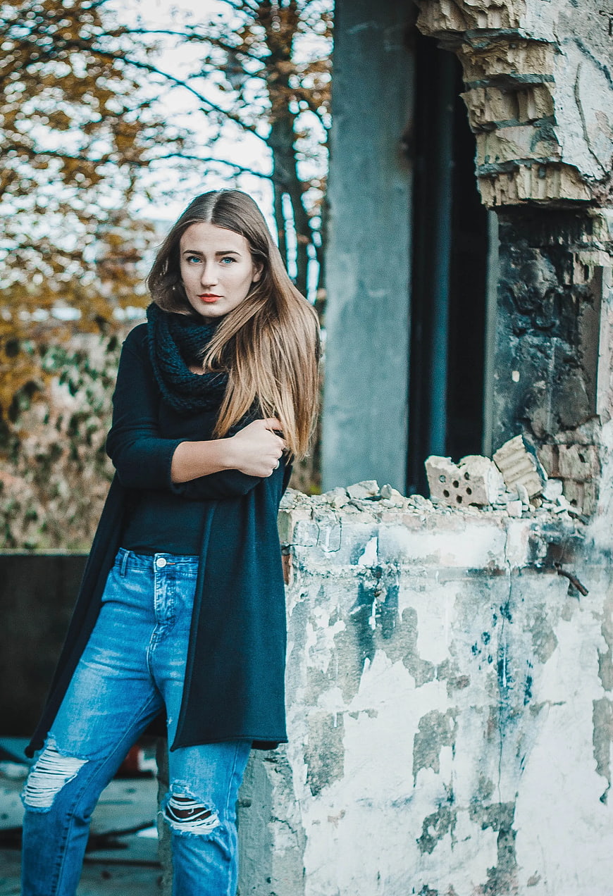 Young Woman in Black Cardigan and Jeans by Ruined Wall