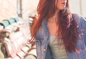 Redhead woman in denim jacket with sunlit hair