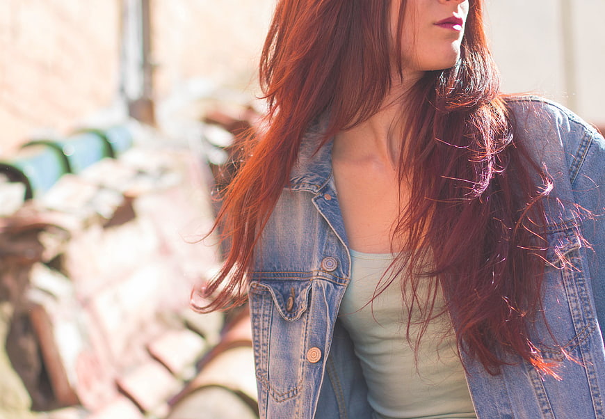Redhead woman in denim jacket with sunlit hair
