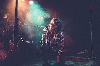 Rock singer performing on stage with dramatic lighting