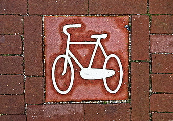 White Bicycle Symbol on Red Brick Pavement