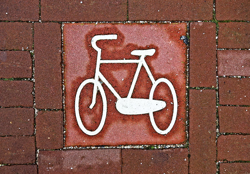 White Bicycle Symbol on Red Brick Pavement