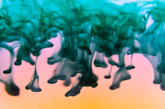 Abstract Teal Ink Swirling in Water with Pink Gradient Background