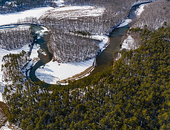 Aerial View of Winding River Through Snowy Winter Forest