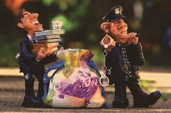 Tax Evasion Concept Figurines with Money Bag and Police Officer