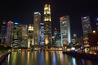 Singapore skyline at night with skyscrapers and river reflections