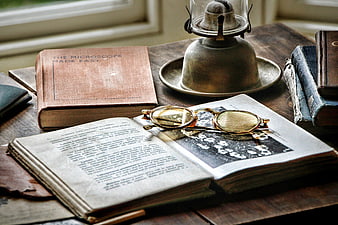 Vintage Books, Spectacles, and Oil Lamp on Wooden Desk