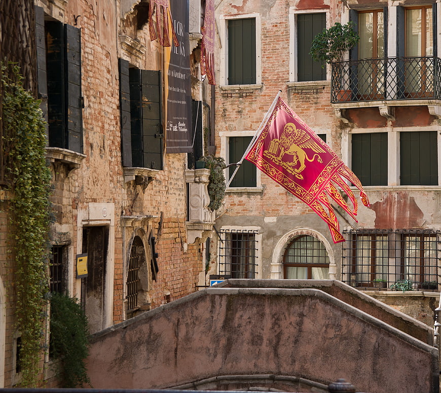 Venetian Lion Flag on Historic Bridge in Venice Italy