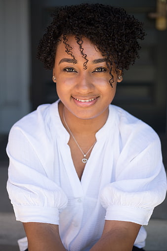 Portrait of smiling young black woman with curly hair
