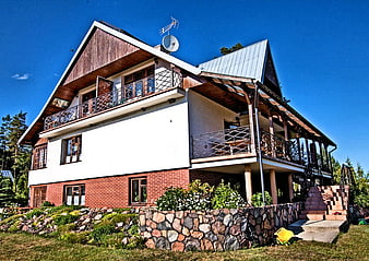 Modern Two-Story House with Wooden Balconies and Stone Wall