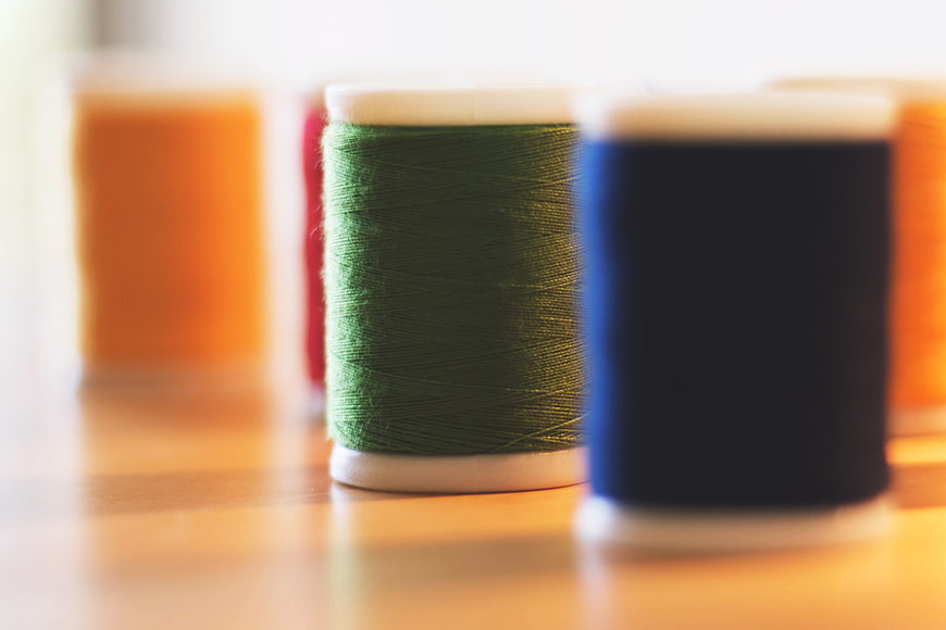 Colorful Spools of Sewing Thread on Wooden Table