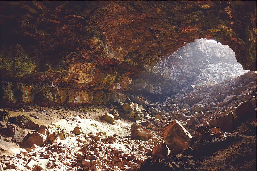 Sunlight streaming through rocky cave entrance with rugged interior