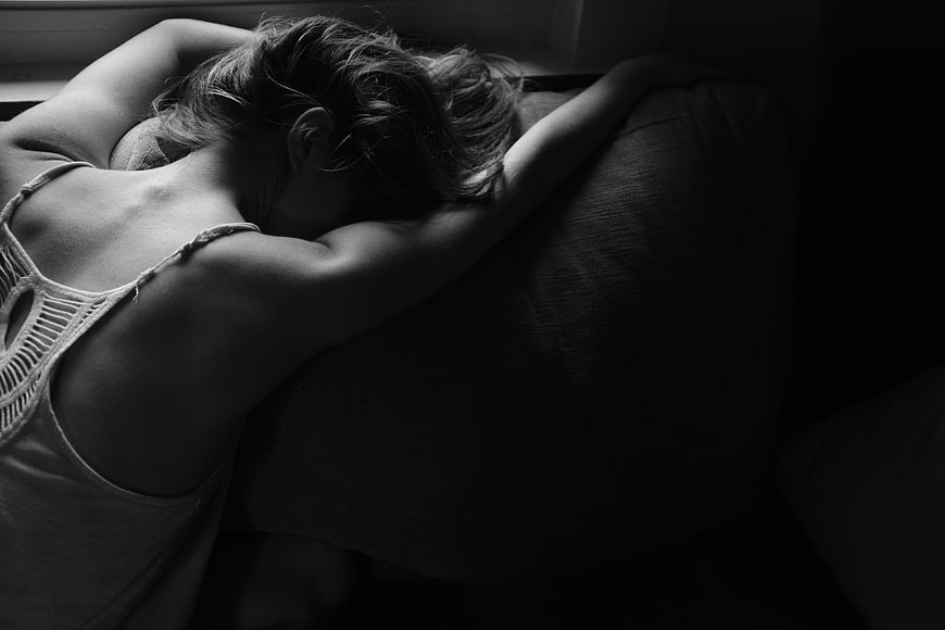 Black and white photo of woman sleeping on bed
