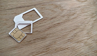 Three-in-one SIM card with adapters on wooden surface