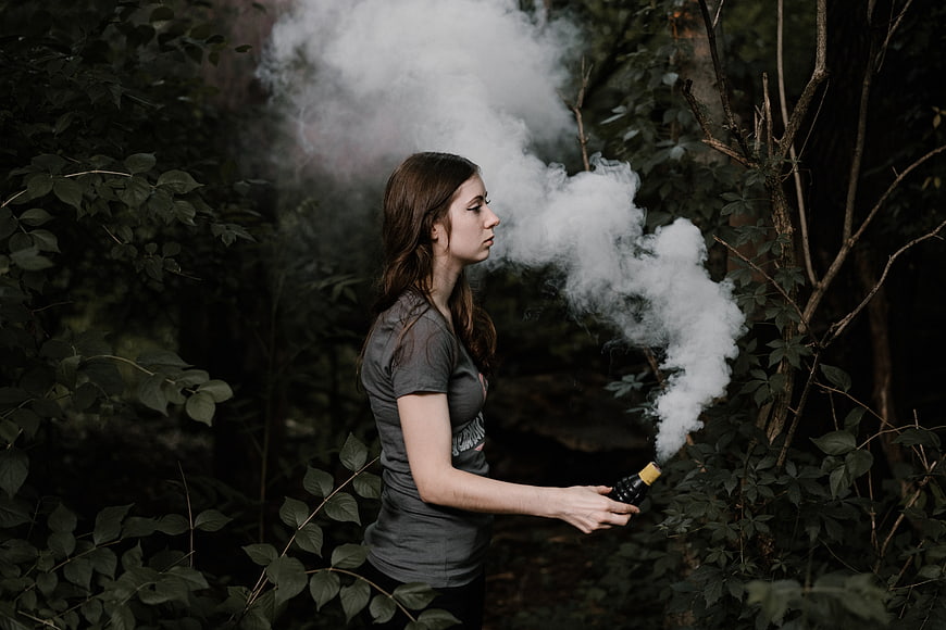 Woman in Forest Holding Smoke Bomb with Thick White Vapor