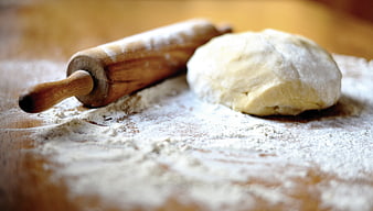 Wooden Rolling Pin And Ball Of Dough On Floured Wooden Surface