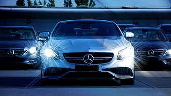 Front view of white Mercedes-Benz with bright headlights