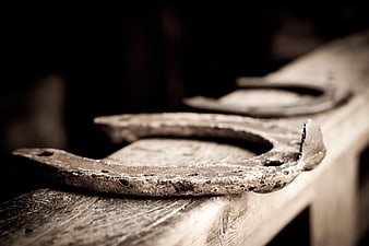 Close-up of rusty old horseshoe on weathered wood