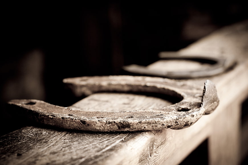 Close-up of rusty old horseshoe on weathered wood