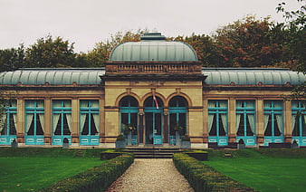 Symmetrical Historic Building with Turquoise Windows and Garden