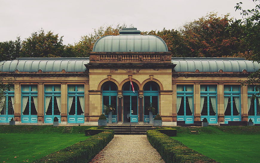 Symmetrical Historic Building with Turquoise Windows and Garden