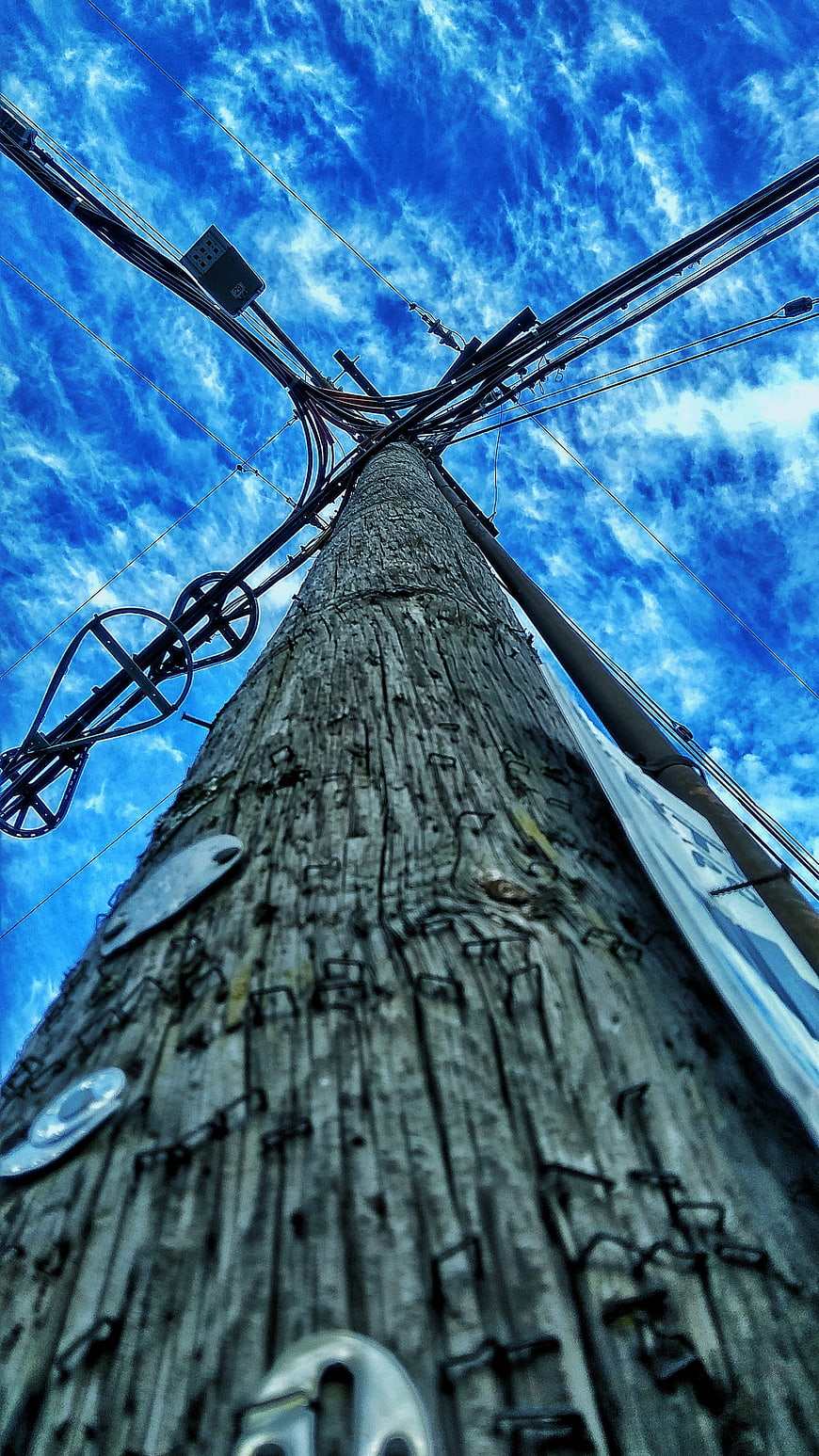 Low angle view of wooden utility pole against blue sky
