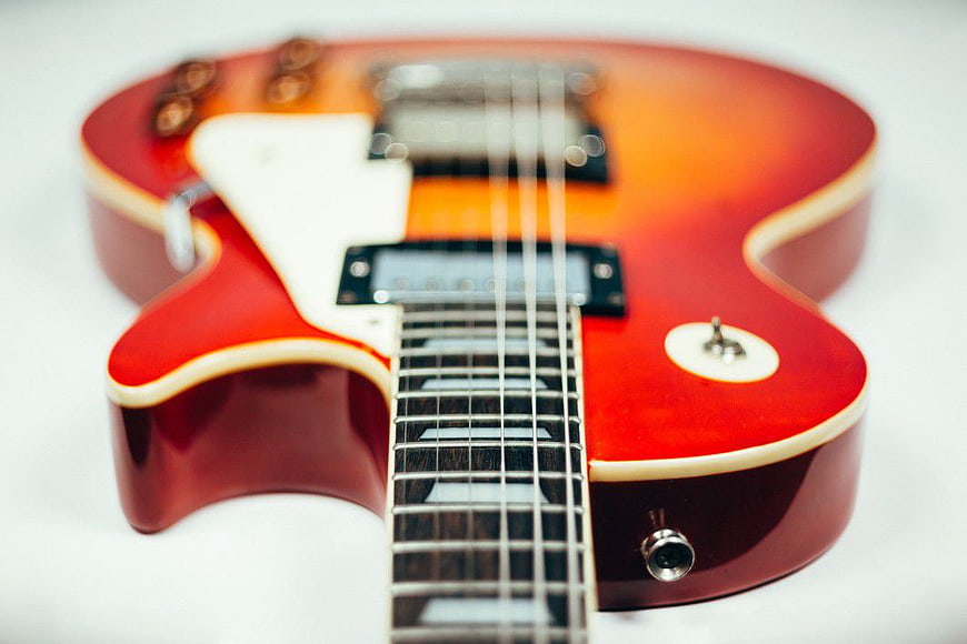 Close-up of Red and Orange Electric Guitar on White Background
