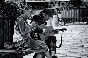 Street Musicians Playing Guitar and Flute on a Bench