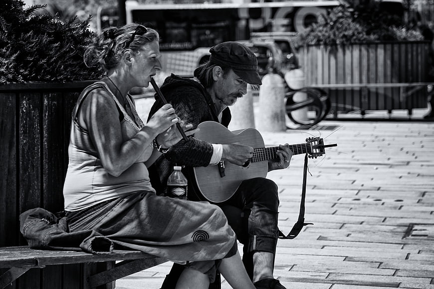 Street Musicians Playing Guitar and Flute on a Bench