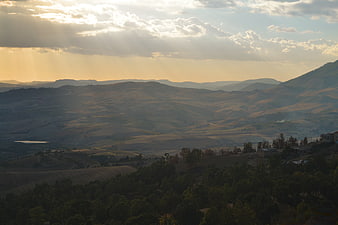 Sunbeams Over Rolling Hills and Valley Landscape