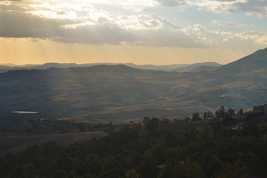 Sunbeams Over Rolling Hills and Valley Landscape