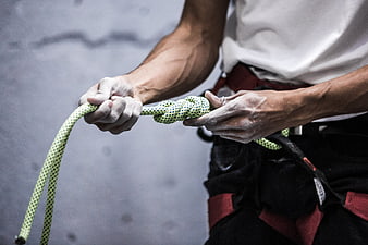 Climber tying knot with chalked hands