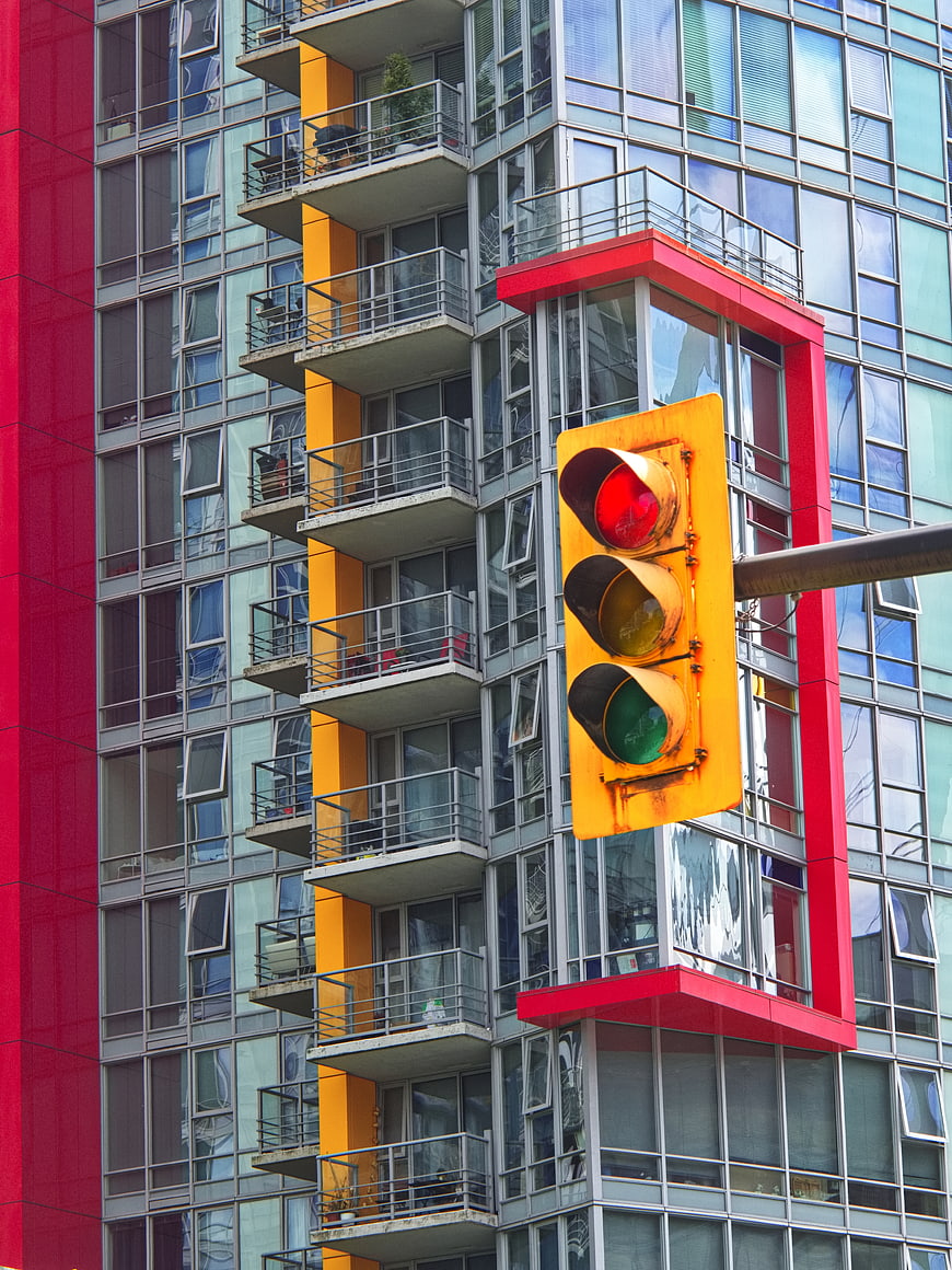 Red Traffic Light Against Colorful Modern Apartment Building