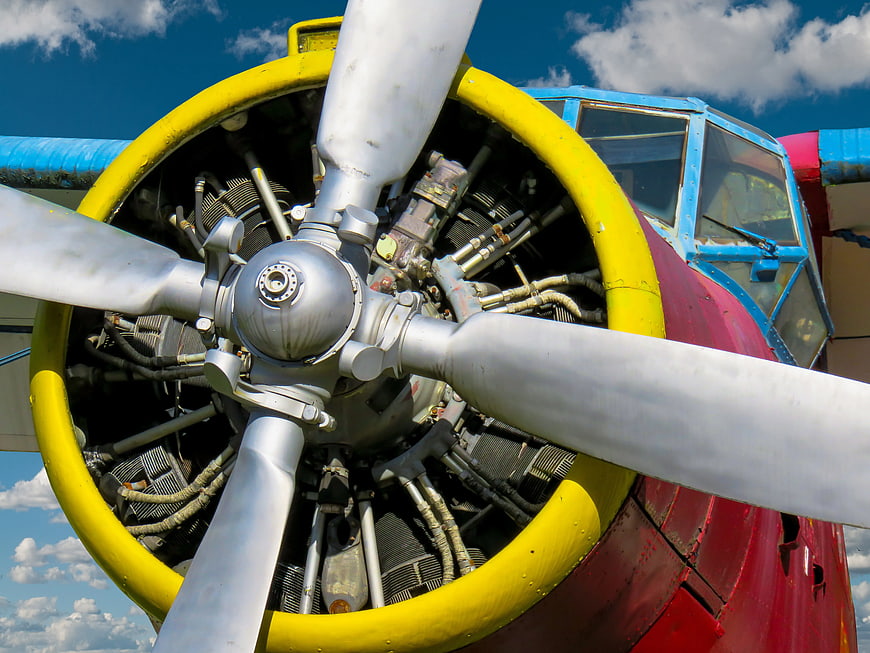 Close-up of vintage airplane propeller engine against blue sky