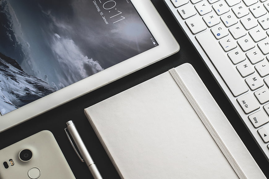 Minimalist workspace with tablet, keyboard, and notebook