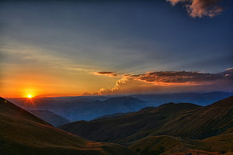 Sunset Over Rolling Mountain Ridges with Golden Sky